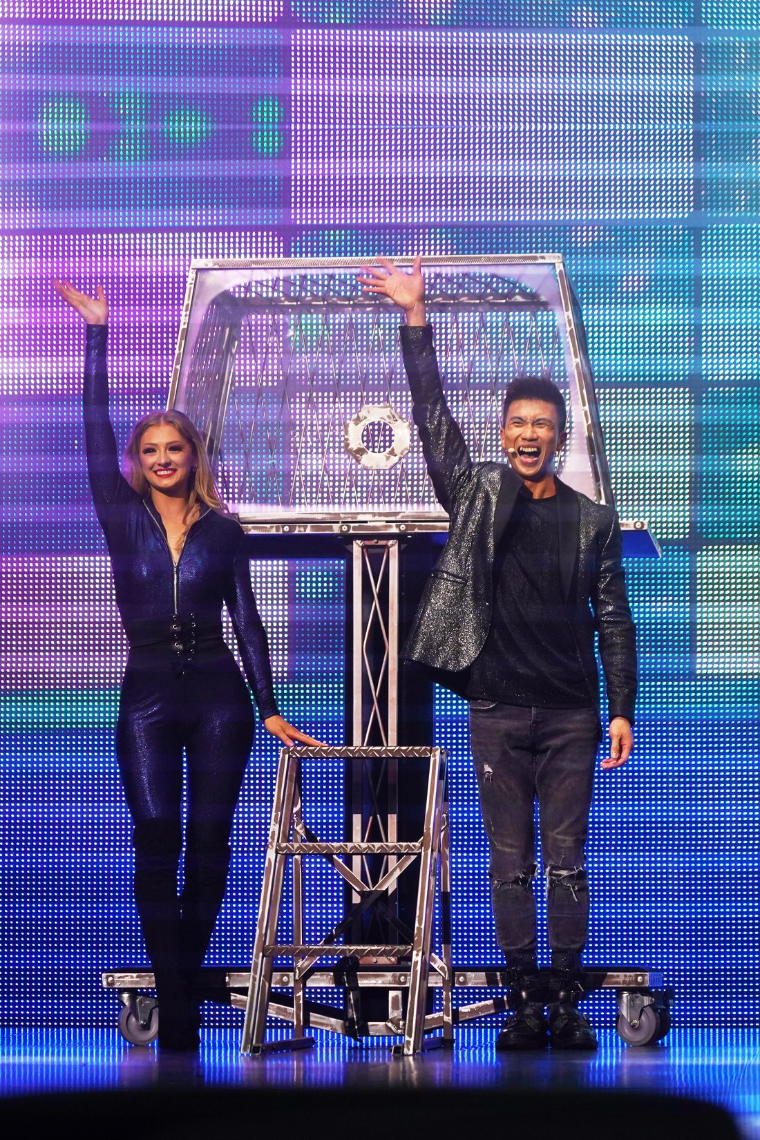 Grand illusion show: a magician and his assistant on stage beside the illusion
