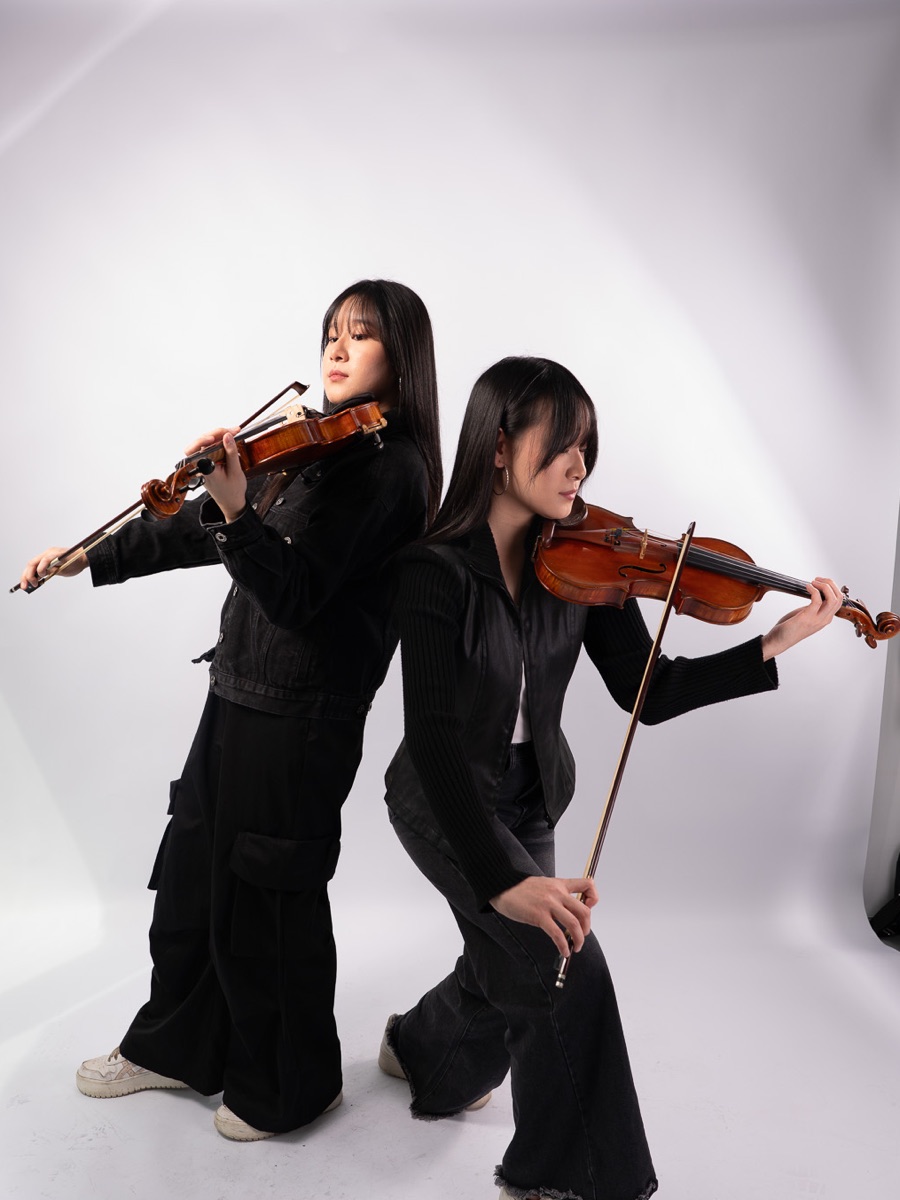 Two violinists in black playing side by side