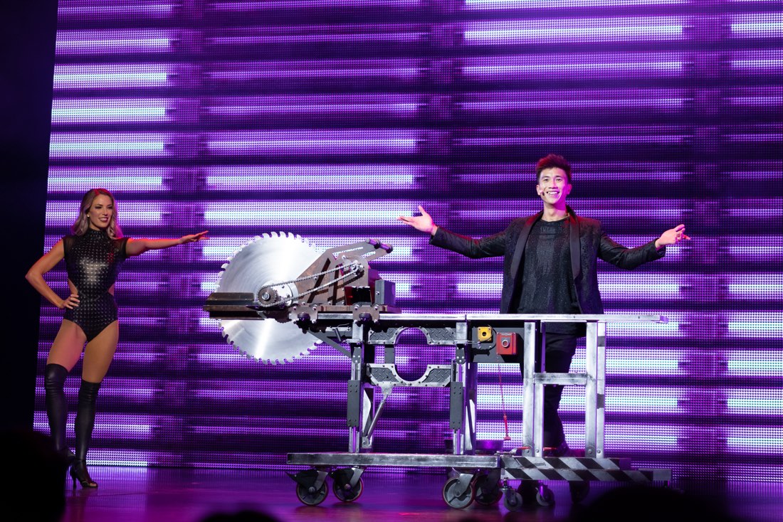 A magician and his assistant presenting a buzz saw illusion